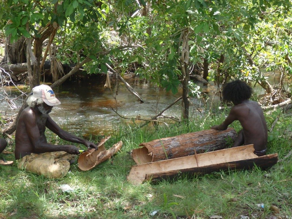 Billy Black (left) and relative cleaning the barks - River crossing near Ramingining © Courtesy of Bula'bula Arts - Photo Daniel Warrakuluma