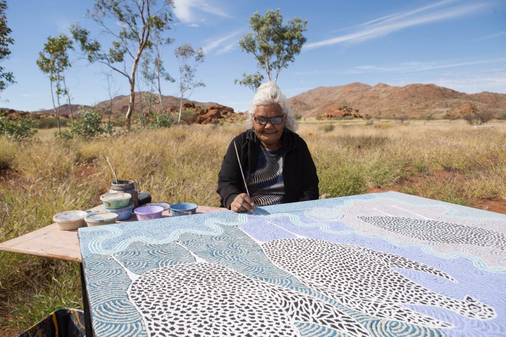 Carlene Thompson painting Kalaya Ngura (Emu Country) in Ernabella - Courtesy Ernabella Arts