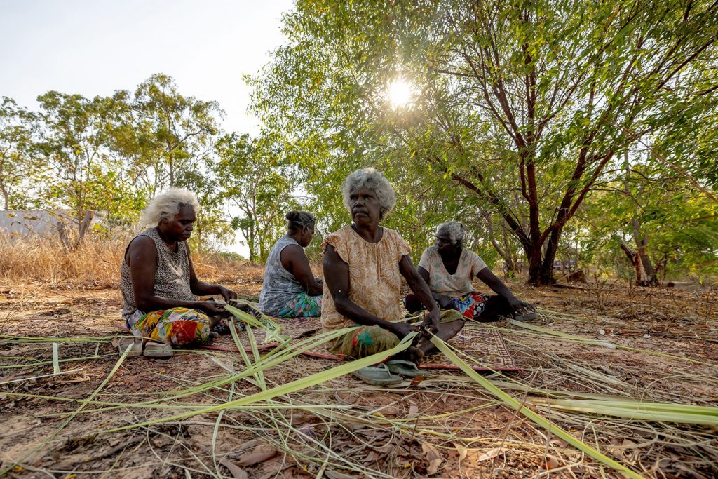 Michelle Baker, Freda Ali, Freda Wayartja Ali and Cecilia Baker, four of the ten principal weavers of Mun-dirra at the National Gallery of Australia, prepare pandanus for dyeing - Photo Renae Saxby, Courtesy National Gallery of Victoria and Maningrida Arts & Culture.